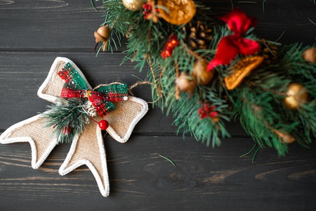 Natural Christmas wreath on black wooden background.