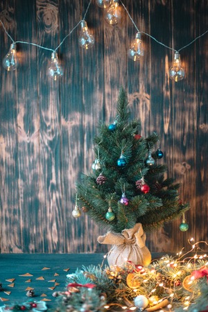 Christmas tree branch and lights on wooden background. View with copy space.の写真素材