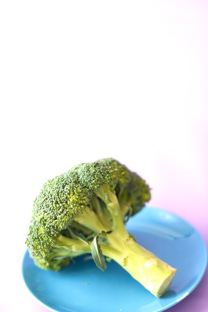 Fresh brocoli on a blue plate on a purple background.の写真素材
