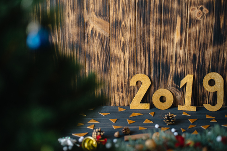 The inscription 2019 on the background of New Year's decorations on a wooden background.の写真素材