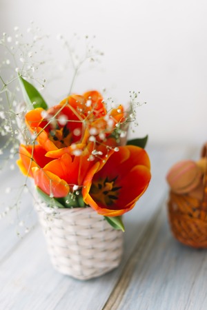 Blossoming tulips near a basket with macaroons.の写真素材
