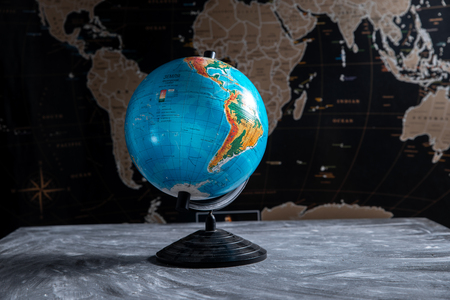 Geographical globe on the background of a black world map.