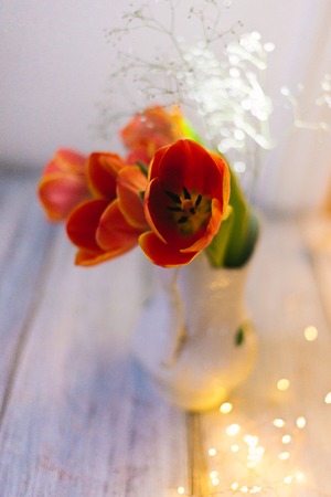 Tulips in a vase on a wooden background.の写真素材