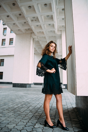 Young girl in green dress near white big building.の写真素材