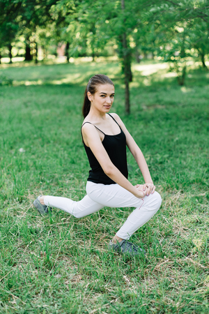 Young beautiful girl doing yoga outdoors in the park.の写真素材