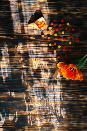 Tulips with sweets in a waffle horn on a wooden background.の写真素材