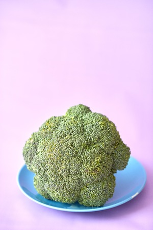 Fresh brocoli on a blue plate on a purple background.の写真素材