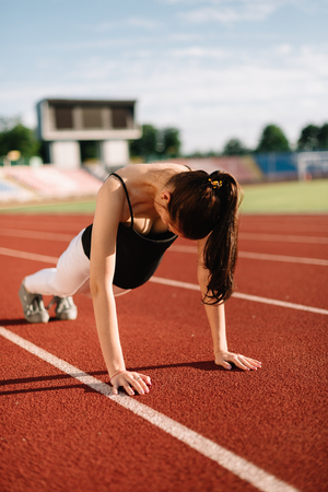 Girl athlete wrung out on the field on a sunny day.の写真素材