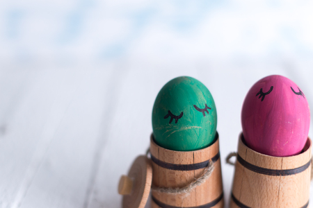 Easter eggs in a small wooden barrel on a blurred background.の写真素材