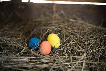 Easter eggs in a basket on a hay with a blurred background.の写真素材