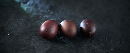 Dark purple eggs on a rough cement background.の写真素材