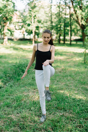 Young beautiful girl doing yoga outdoors in the park.の写真素材