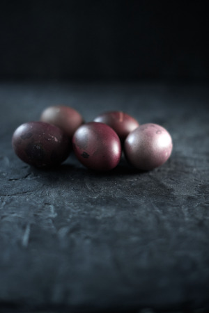Dark purple eggs on a rough cement background.の写真素材