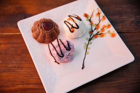Cupcake in a cafe on a wooden background on a white plate.の写真素材