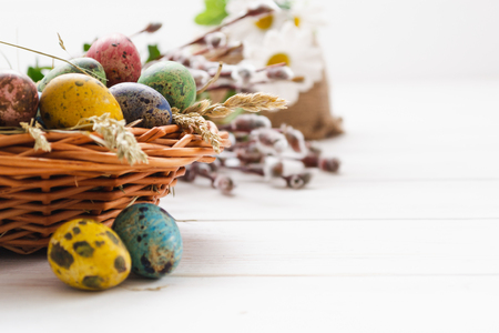 Easter eggs in a basket on a white wooden background.の写真素材