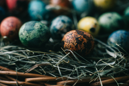 Quail Easter eggs in a basket on the hay. Easter concept.の写真素材