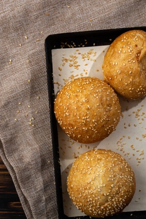 Homemade buns on burlap on wooden background.の写真素材