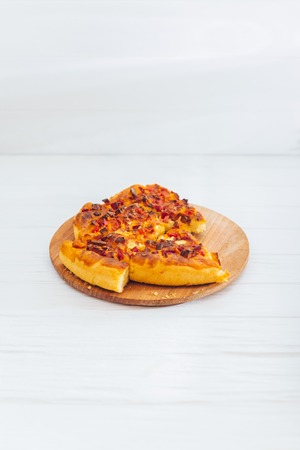 Homemade pizza on white wooden background on kitchen board.の写真素材