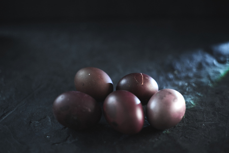 Dark purple eggs on a rough cement background.の写真素材