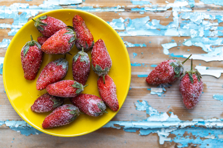 Frozen strawberries on a wooden blue background.の写真素材
