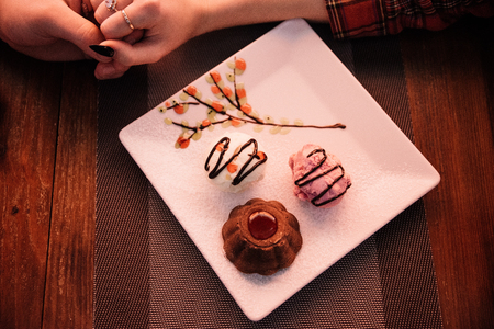 Cupcake in a cafe on a wooden background on a white plate.の写真素材