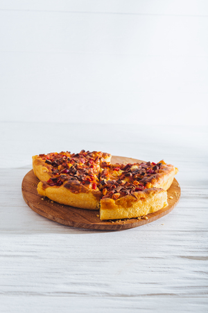 Homemade pizza on white wooden background on kitchen board.の写真素材