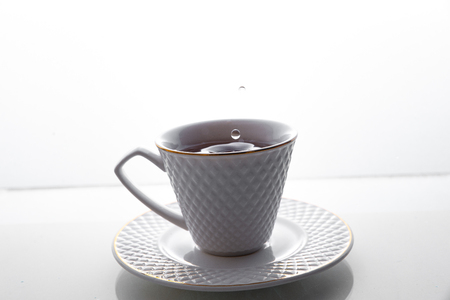Tea splashes in a cup on a white background.の写真素材