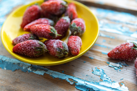 Frozen strawberries on a wooden blue background.の写真素材