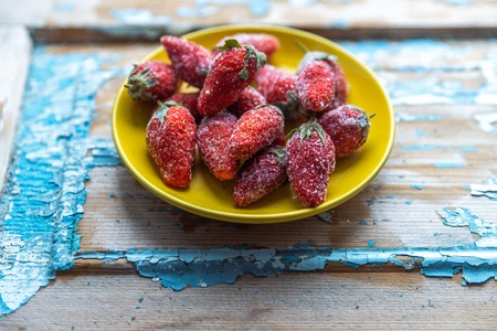 Frozen strawberries on a wooden blue background.の写真素材
