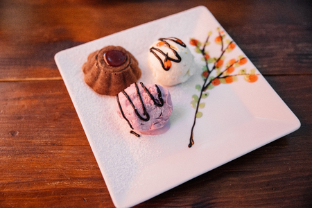 Cupcake in a cafe on a wooden background on a white plate.の写真素材