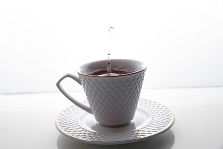 Tea splashes in a cup on a white background.の写真素材