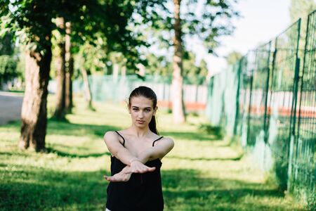 Young beautiful girl doing yoga outdoors in the park.の写真素材