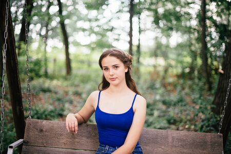 Beautiful girl in short shorts and a blue T-shirt in the woods.の写真素材