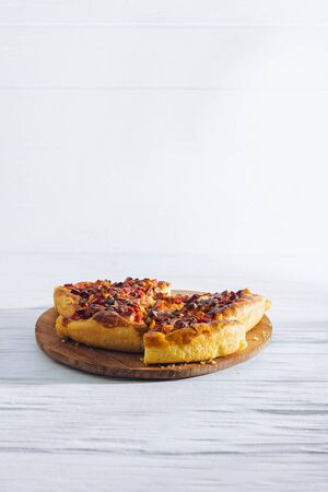 Homemade pizza on white wooden background on kitchen board.の写真素材