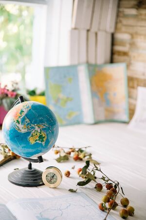 Globe on wooden white boards with a blurred background. Autumn still life.の写真素材