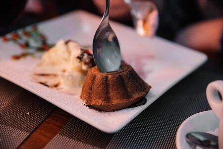 Cupcake in a cafe on a wooden background on a white plate.の写真素材