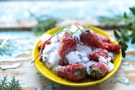 Frozen strawberries on a wooden blue background.の写真素材