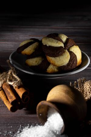 Cookies and barrel small with sugar on a dark wooden background.