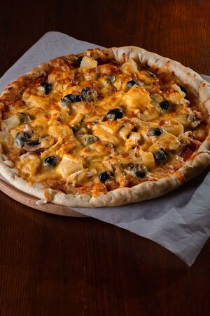 Pizza on a wooden dark background in a bar.の写真素材