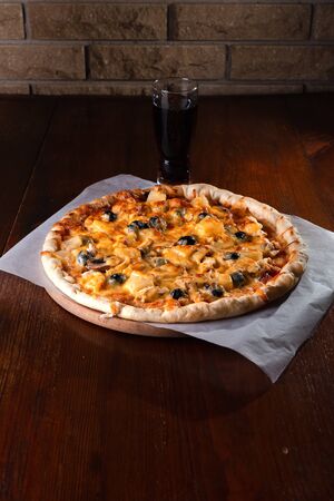 Pizza on a wooden dark background in a bar.の写真素材