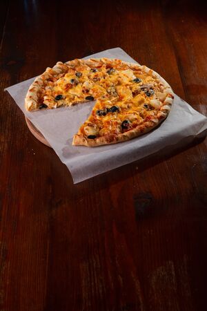 Pizza on a wooden dark background in a bar.の写真素材