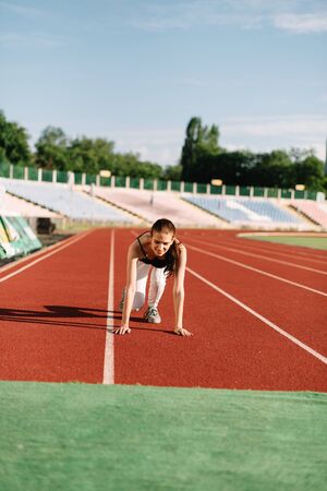 Girl athlete on the treadmill at the start before running.