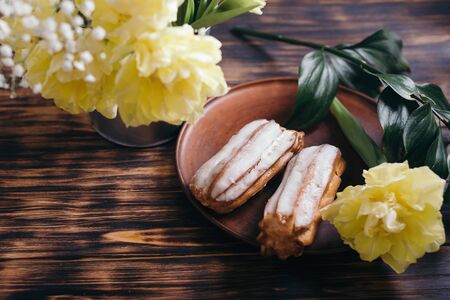 Choux cake on a wooden background with tulips.の写真素材