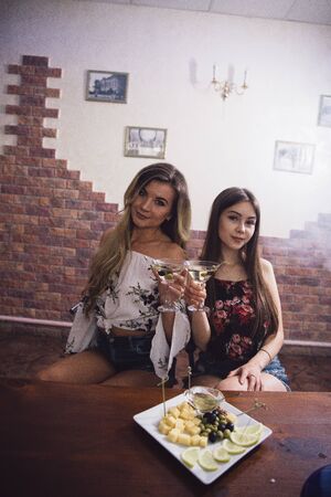 Two girls at a table with snacks and hookah at a nightclub.の写真素材