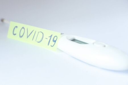 Thermometer with the inscription coronavirus on a light background. Concept.の写真素材