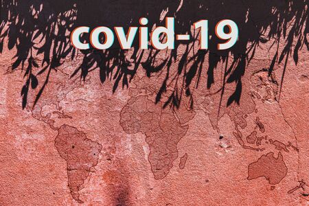 The inscription Coronavirus with glitch effect on the background of a red world map on concrete.の写真素材