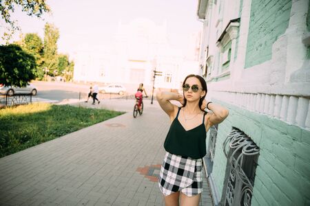 Sexy girl in a T-shirt and short shorts near the building.の写真素材