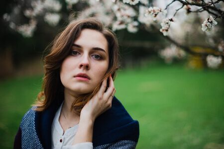 Beautiful young girl is resting and enjoying spring in the spring park.