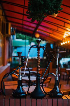 Stylish wooden hookah in the evening on a summer terrace in a cafe.