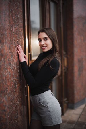 Street urban shooting. Girl on a textured background in the city.の写真素材